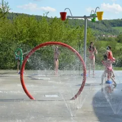 Zone de jeux aquatique avec jets d'eau et enfants jouant, Camping Du Bois de Reveuge