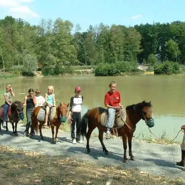 Enfants à cheval près d'un lac au Camping Du Bois de Reveuge.