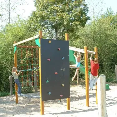 Enfants qui jouent sur un parcours d'escalade au Camping Du Bois de Reveuge.
