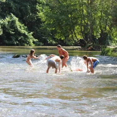 Famille qui joue dans une rivière à Camping Grand Sud
