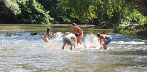 Famille qui joue dans une rivière à Camping Grand Sud