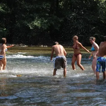Quatre personnes dans une rivière à Camping Grand Sud