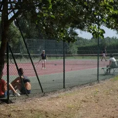 Deux personnes jouant au tennis sur un court extérieur à Camping Grand Sud