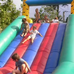 Enfants qui descendent une toboggan gonflable au Camping Val Roma Park