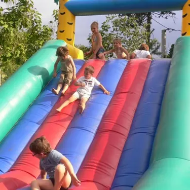 Enfants qui descendent une toboggan gonflable au Camping Val Roma Park
