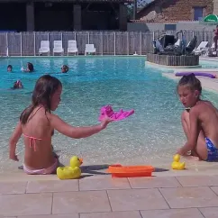 Enfants jouant avec des canards en plastique dans la piscine du Camping Des Etangs