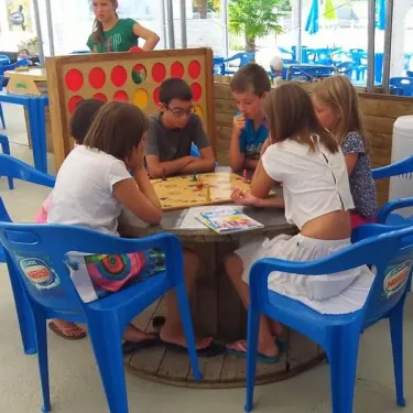 Enfants jouant à un jeu de société au Camping Des Etangs