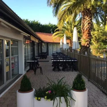 Camping Bela Basque - terrasse avec tables et parasols