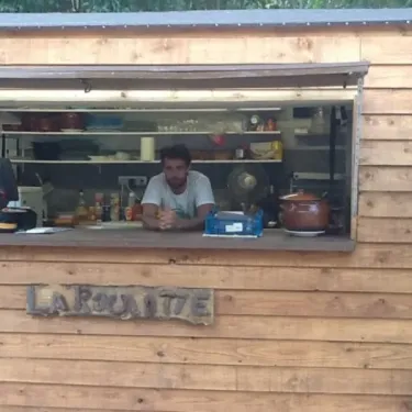 La Bouteille, kiosque en bois avec un homme derrière le comptoir.