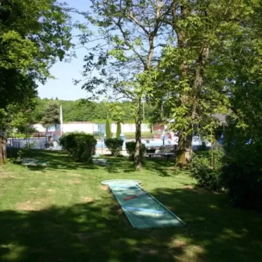 Camping Le Manoir de Bezolle : parcours mini-golf en herbe entouré d'arbres