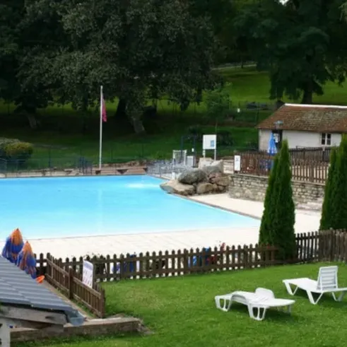 Piscine avec chaises longues et arbres autour du Camping Le Manoir de Bezolle