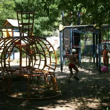 Enfants jouant sur un parc infantile en bois au Camping Aloha Plage