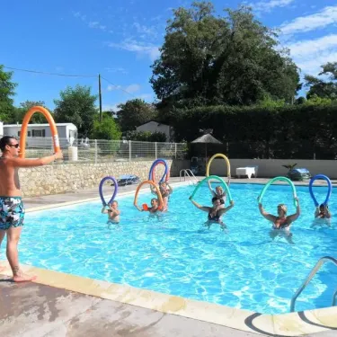 Camping Aloha Plage : groupe dans la piscine avec anneaux flottants colorés