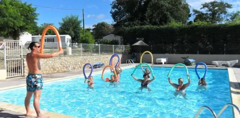 Camping Aloha Plage : groupe dans la piscine avec anneaux flottants colorés