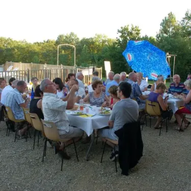 Groupes de personnes dînant en plein air au Camping de Bergougne.