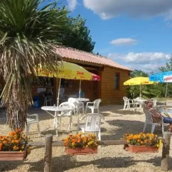 Terrasse avec parasols et tables, Camping De Bergougne