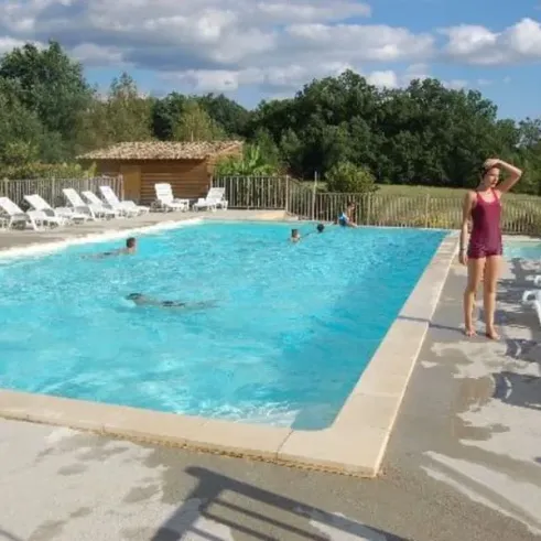 Piscine extérieure avec chaises longues blanches autour