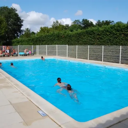 Piscine avec des enfants nageant au Camping Le Chant des Oiseaux