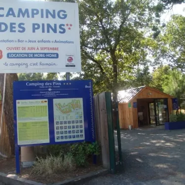 Panneau d'entrée du Camping des Pins avec piscine et location de mobil-home.