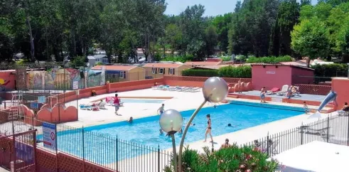 Piscine entourée d'arbres avec vélos au Camping le Sourire