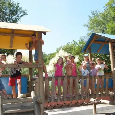 Enfants sur un parcours de jeux en bois à Camping le Sourire
