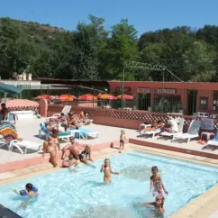 Camping le Sourire : piscine avec enfants et adultes, chaises longues et parasols.