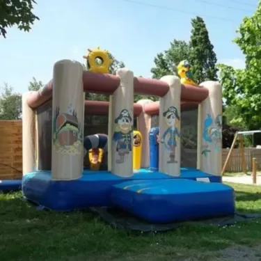 Camping le Beauchêne : manège gonflable pirate pour enfants sur gazon