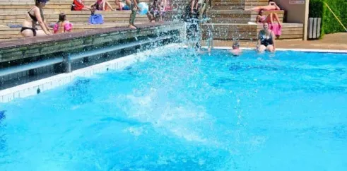 Camping Le Colporteur : enfants sautant dans la piscine en plein été