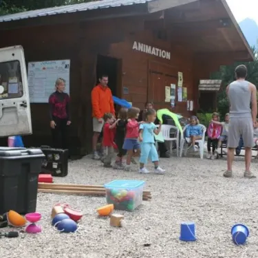 Camping Le Colporteur : enfants jouent près d'un espace animation avec jouets colorés sur le sol.
