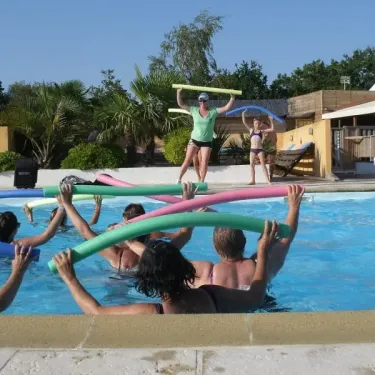 Groupes faisant des exercices aquatiques avec des tubes flottants dans la piscine