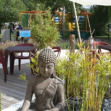 Statue du Bouddha dans un jardin zen au Camping La Baie Dorée