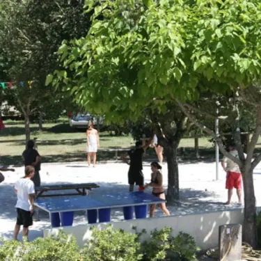 Camping Des Familles : groupe jouant au ping-pong sous les arbres