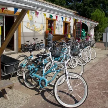 Camping Des Familles : vélos alignés devant un kiosque décoré de fanions