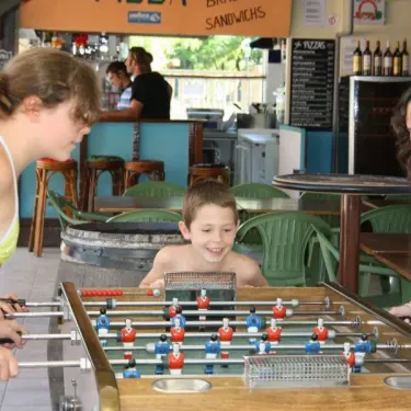 Enfants jouant au football sur table dans le camping Des Familles.