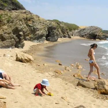 Famille sur une plage rocheuse près de l'océan à Camping L'Océan Breton.