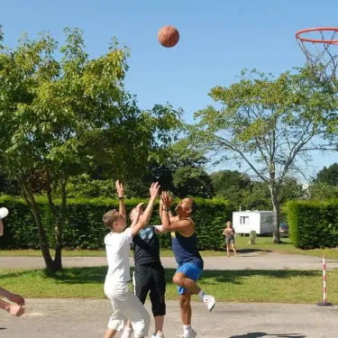 Enfants jouent au basket-ball à Camping L'Océan Breton.