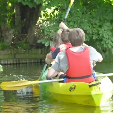 Deux enfants en kayak sur un canal, près de Camping du Port Mulon.