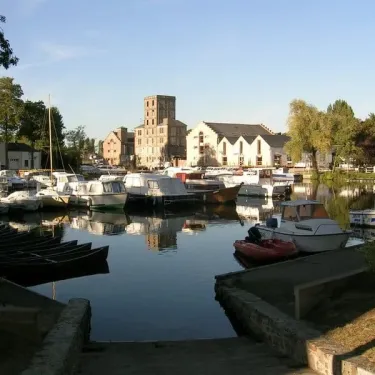 Port avec bateaux amarrés et bâtiments à l'horizon au Camping du Port Mulon