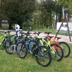 Vélos alignés sur l'herbe près d'une cabane et d'un parc de camping au Camping du Port Mulon