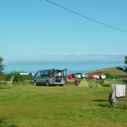 Tentes et véhicules dans un espace vert au Camping Pré de la Mer