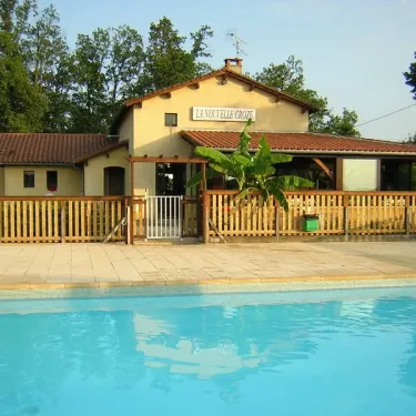 Bâtiment du camping La Nouvelle Croze avec piscine en arrière-plan