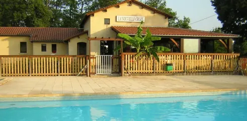 Bâtiment du camping La Nouvelle Croze avec piscine en arrière-plan