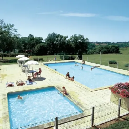 Piscine extérieure avec chaises longues et parasols au Camping La Nouvelle Croze