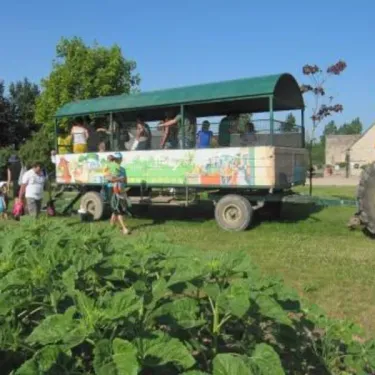 Véhicule aménagé poussée par une tractoplane dans un champ au Camping Ferme de Prunay