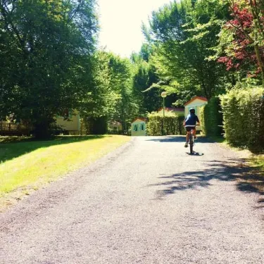 Camping La Plage de Garoustel : personne à vélo sur route en forêt