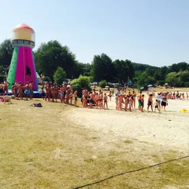 Camping La Plage de Garoustel : groupe d'enfants tenant leurs dessins devant une affiche de mains imprimées.