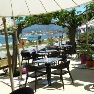 Tableau de terrasse au Camping U Pezzo avec vue sur la mer et un port