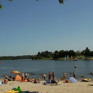 Plage animée avec parasols et baignade, Camping Des Lacs