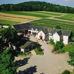 Camping Le Manoir de Bezolle avec bâtiments et champs agricoles en arrière-plan