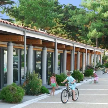 Enfants à vélo devant le bâtiment du camping Les Grenettes